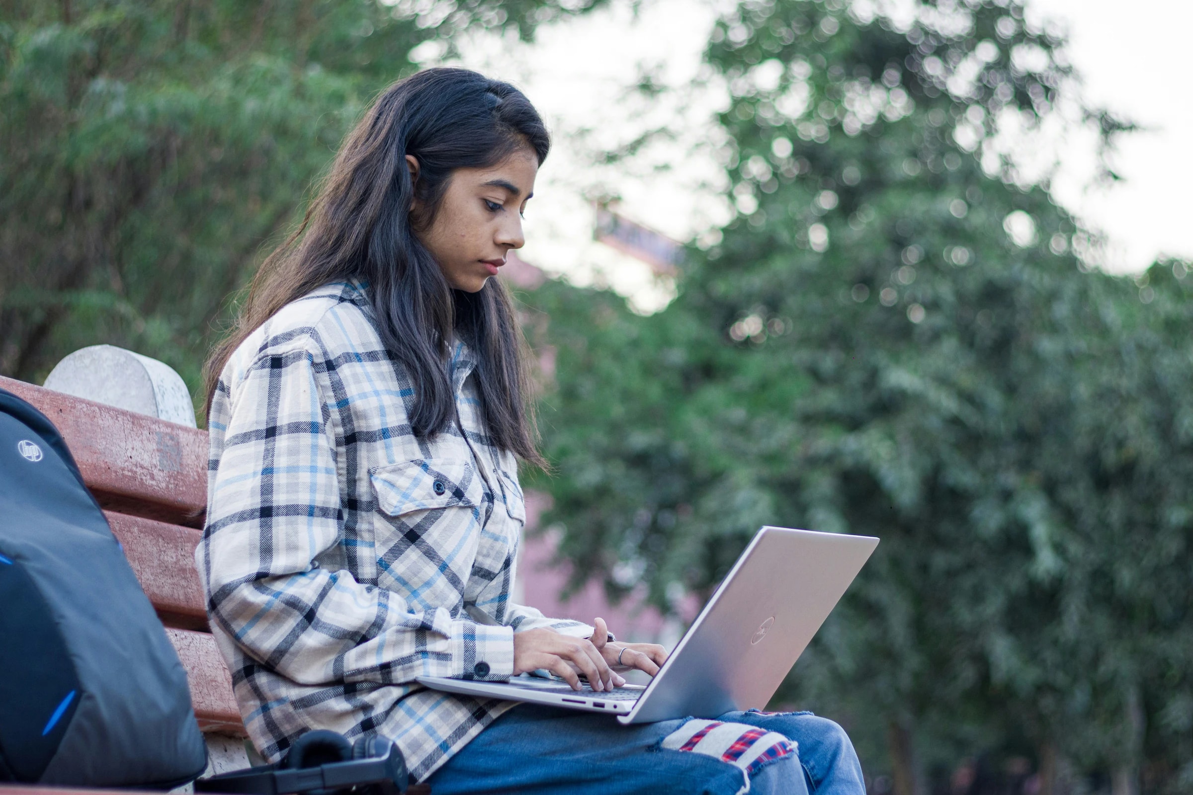 A student studying outdoors on her laptop